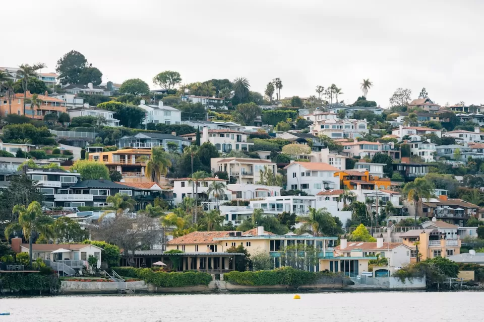 Dense neighborhood of homes on a hillside on the water in San Diego, California.